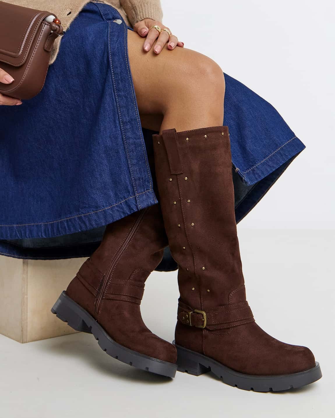 Close-up of a model wearing brown knee high biker boots.