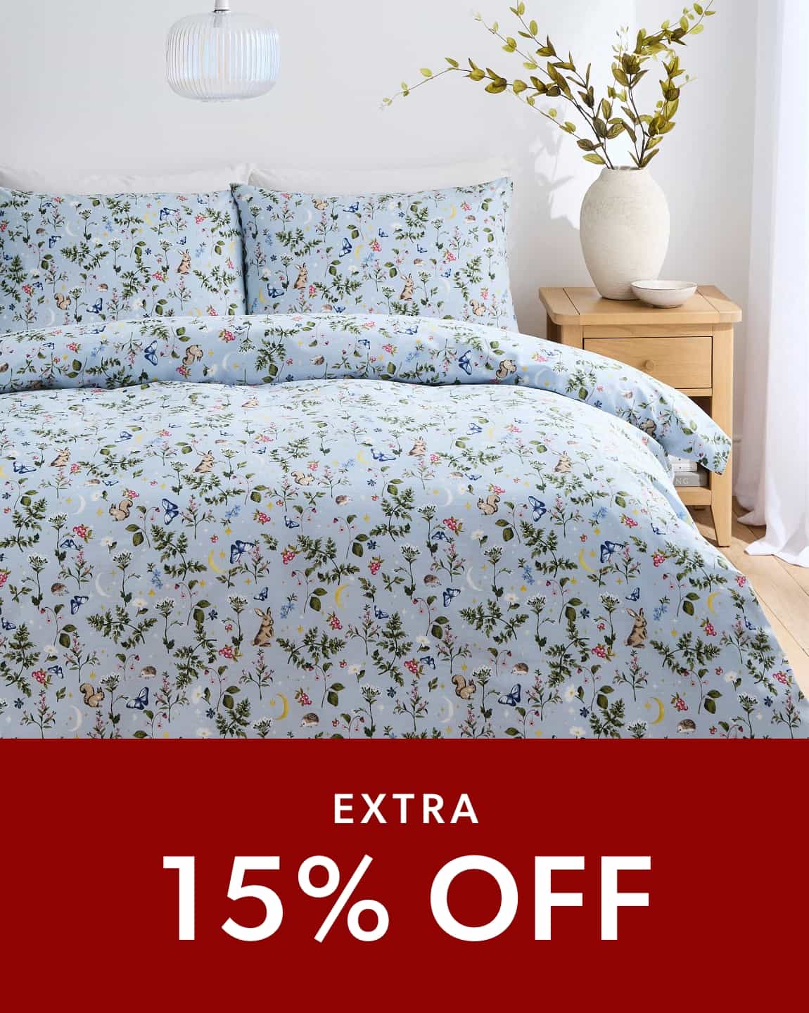 A double bed with a blue summer meadow duvet cover set.
