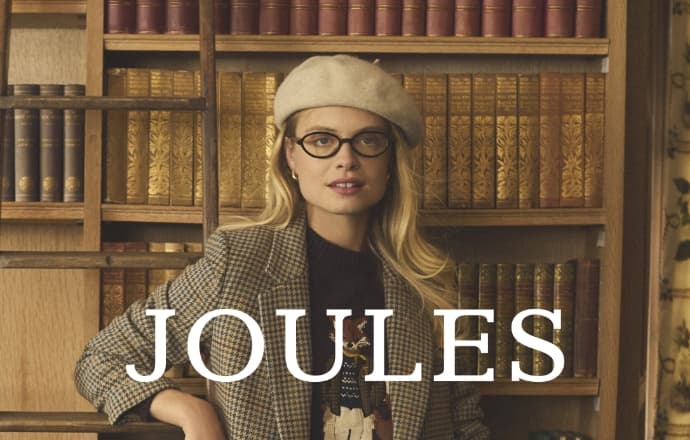 Elegant Woman In Tweed Jacket And Beret Poses In Library For Stylish Fashion Portrait Shoot