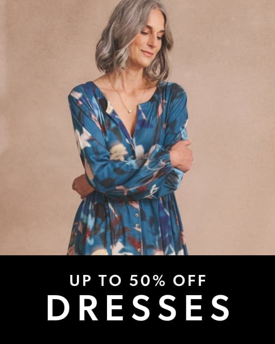 A person wearing a long-sleeved, blue dress with a colourful abstract floral pattern.