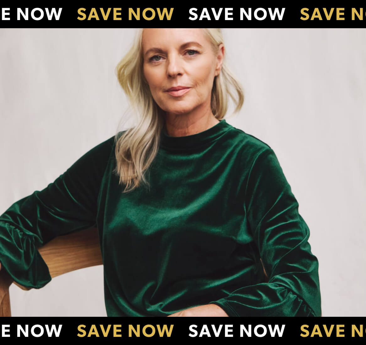 Promotional banner featuring a woman with blonde hair wearing an emerald green velvet top, seated on a wooden chair.